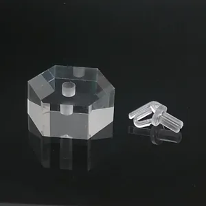 Vue détaillée de support de bague en acrylique transparent, base hexagonale et accessoire.