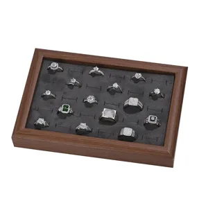 Wooden jewelry tray with gray velvet slot insert for displaying rings and earrings safely.