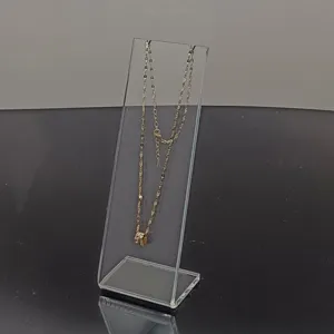 Soporte de exhibición acrílico transparente con collar dorado fino, vista detallada.