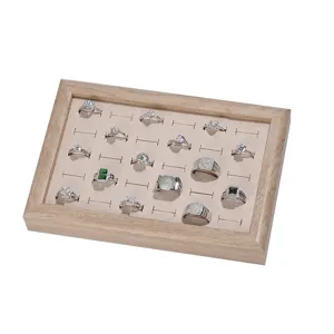 Solid wood jewelry display tray with beige velvet slot insert and multiple fashion rings.