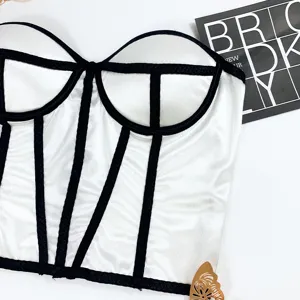 Detail view of a stylish white and black corset crop top with padding and structured boning.