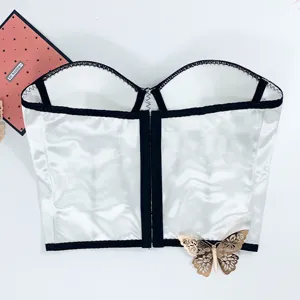 White satin strapless bustier top detail, contrast black trim and gold butterfly accent.