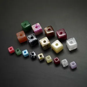 Vue détaillée de perles carrées en acrylique coloré avec de grands trous, parfaites pour les bijoux.