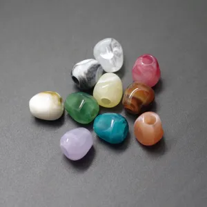 Dettaglio perle in acrilico colorate con foro grande, ideale per accessori fai da te.