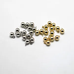 Silver and gold CCB plastic ball charms with loops for DIY jewelry making, detailed view.