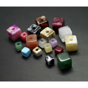 Gros plan de perles carrées en acrylique coloré, design marbré détail pour loisirs créatifs.