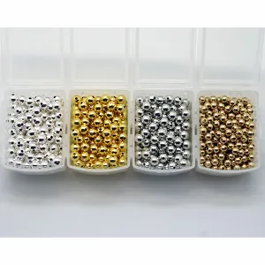 Close-up detail of smooth metallic round beads in clear boxes for DIY jewelry making crafts.