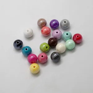 Colorful acrylic loose beads closeup showing glossy surface and center hole for DIY jewelry.