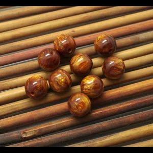 Close-up detail shot of golden textured resin loose beads for DIY handmade jewelry accessories.