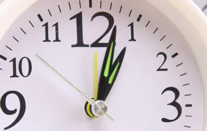 Primer plano detallado de la esfera de reloj blanca minimalista con numeros y agujas negros.