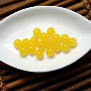 Detalle de cuentas redondas de acrílico amarillo transparente para la creación de joyas de bricolaje.
