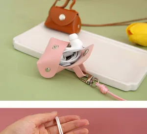 Gedetailleerde close-up van een roze mini PU lederen oortelefoon organizer etui met riem.