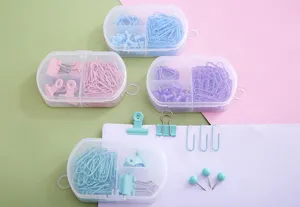 Joli set de papeterie pastel avec trombones, pinces et punaises dans des boîtes.