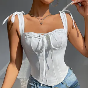 Close-up detail of white corset camisole with tie straps and lace-up front design.