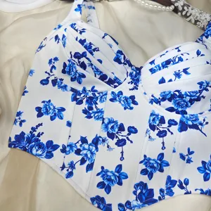 Detalle de top corsé floral azul y blanco, bustier elegante sin mangas con ballenas y tirantes finos.