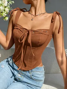 Close-up detail of brown corset camisole with bow tie straps and lace-up front design.