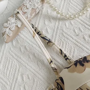 Close-up detail shot of vintage floral print camisole strap and delicate garment texture.