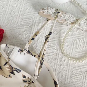 Floral crop top strap detail view, delicate lace hanger and pearls background decoration.