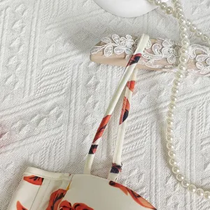 Floral crop top strap detail view, featuring delicate floral print and adjustable straps.