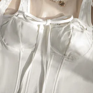 Detailed close-up shot of a chic white slim-fit corset camisole featuring stylish bow tie and boning.