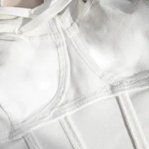 Detail view of white slim-fit fishbone strap vest showing fine stitching and fabric.