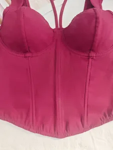 Detail close-up view of dark pink corset bustier top with boning design and thin straps.