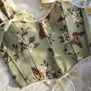 Top corsé vintage de jacquard floral verde con bonitos tirantes de cinta y cordones atrás.