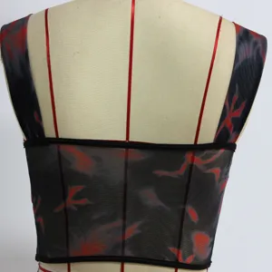Back detail of the red and black mesh crop top featuring slim straps and boning structure.