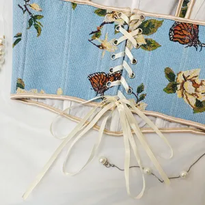 Vista detallada del corsé de jacquard floral con cordones de cinta y estampado mariposa.