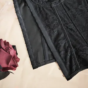 Black lace corset detail close up, featuring mesh texture and secure hook and eye closure.