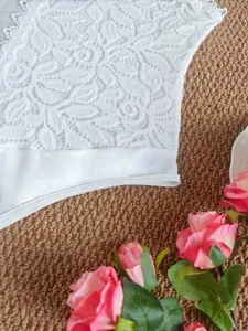Detail de body en dentelle blanche, gros plan haut floral en maille transparente, vetement femme.