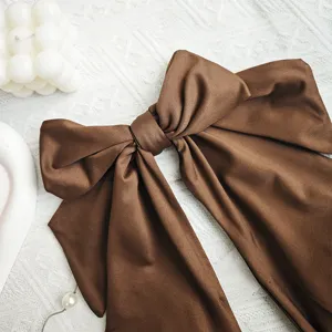 Elegante fiocco in tessuto marrone, ideale per acconciature o decorazione. Alta qualità.