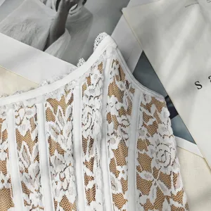 Close-up of white lace bustier top, featuring intricate floral lace and supportive boning.