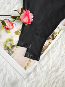 Detailed close-up of women's black bodysuit snap closure, soft breathable mesh fabric design.