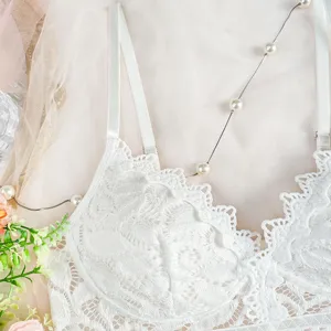 Weisse Spitzen-Cami im Detail, florales Bustier mit Lochmuster und Perlenketten-Deko.