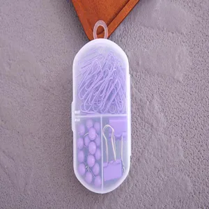 Vue détaillée de l'ensemble de papeterie violet avec trombones, punaises et pinces dans une boîte.
