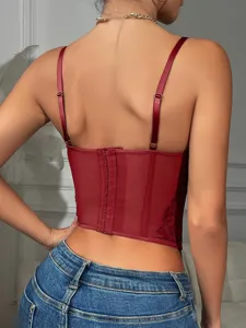 Detail of a red satin lace corset top with adjustable straps and back hook closure.