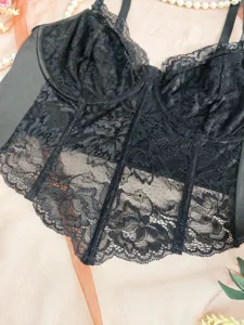 Detailed view of black lace plus size bustier bra with fishbone support and delicate patterns.