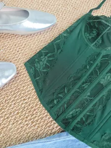 Dark green lace corset top detail view, featuring mesh stitching and delicate bustier design.
