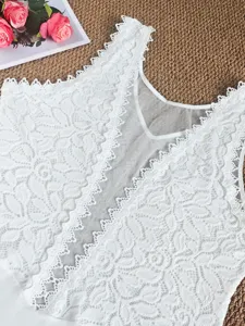 Superbe body sans manches en dentelle blanche avec empiècements en tulle et motifs floraux.