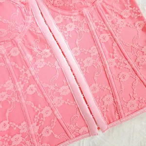 Close-up detail view of pink floral lace corset top showing front boning and hook closure.