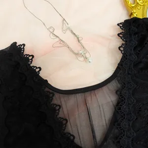 Détail de body en dentelle noire mettant en valeur la bordure florale et le col en V.