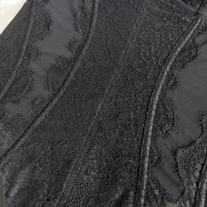 Detailed view of black lace mesh spliced bodysuit, featuring delicate floral embroidery and sheer fabric.