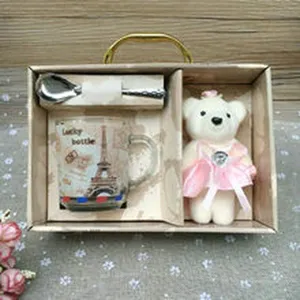 Set de regalo con taza de vidrio con torre Eiffel, cuchara y tierno oso de peluche.