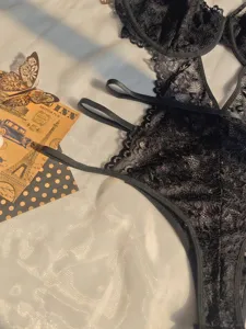 Detailed view of women's sexy black lace sheer wired bodysuit, delicate floral lace pattern close-up.