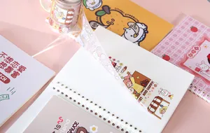 Schattig cartoon ringbandnotitieboekje met releasepapier en washi tape voor journaling.