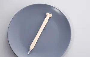 Close-up van een grappige botvormige gelpen in romig beige, schattig schrijfwaren detail.