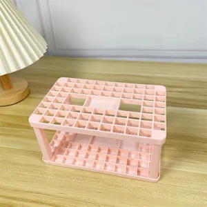 Pratico organizzatore da scrivania rosa con vari fori per pennelli da trucco e penne.