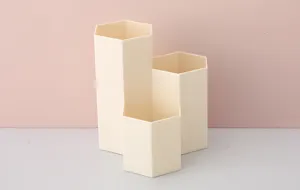 Detailansicht des modernen, beigen hexagonalen Stiftehalters mit praktischem, mehrstufigem Design.
