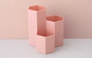 Detailansicht des rosa wabenförmigen Multi-Raster-Stifte- und Make-up-Pinsel-Aufbewahrungsbox.